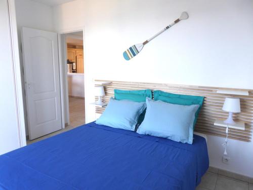 - un lit bleu avec des oreillers bleus dans une chambre dans l'établissement Appartement mer, 6 couchages Sainte Maxime, à Sainte-Maxime