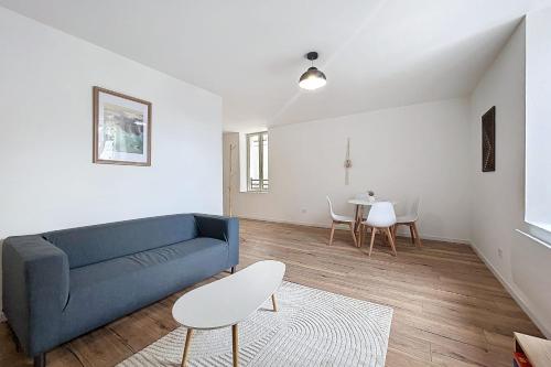 a living room with a blue couch and a table at Bright 1-bedroom apartment in Cuxac-dʼAude
