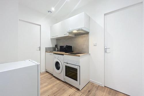 - une cuisine avec un lave-linge et un sèche-linge à côté d'une porte dans l'établissement Bright 1-bedroom apartment, à Cuxac-dʼAude