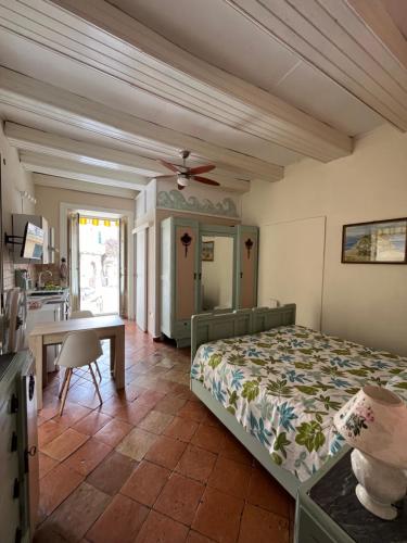 a bedroom with a bed and a desk and a kitchen at A casa di Nicoletta in Tropea