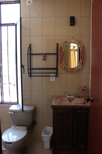 a bathroom with a toilet and a sink and a mirror at Hotel suites Guanajuato Centrico in Guanajuato