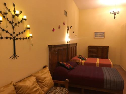 a bedroom with two beds and a tree on the wall at Hotel suites Guanajuato Centrico in Guanajuato