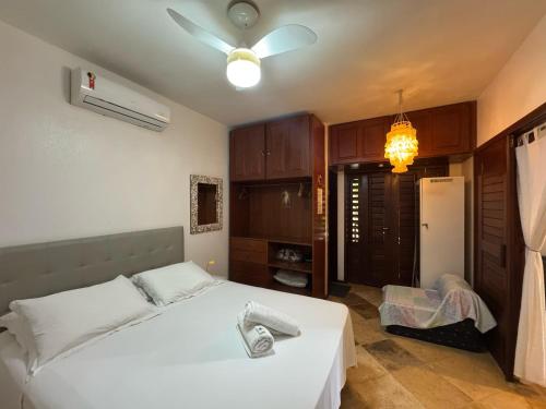 a bedroom with a white bed and a ceiling fan at Serrote Breezes Apartamento 04 in Jericoacoara