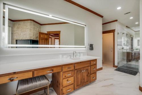 a bathroom with a sink and a large mirror at 22-Acres Mansion - Pool Party Venue Games & More in Garland