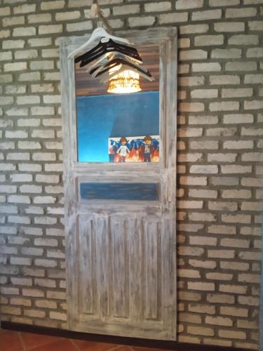 a door in a brick wall with a light at Pousada Aquarela Pipa in Pipa