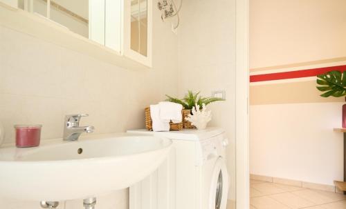 a white bathroom with a sink and a mirror at HomeSerra 2 in Bologna