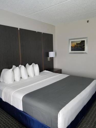 a hotel room with a large bed with white pillows at Best Western Ocala Park Centre in Ocala
