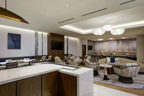 a lobby with a waiting area with tables and chairs at The Westin Oaks Houston at the Galleria in Houston