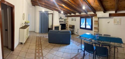 a living room with a table and a blue couch at La villa di Turi in Castellammare del Golfo