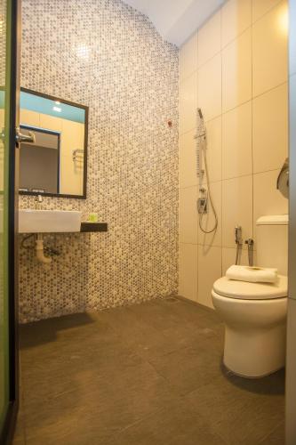 a bathroom with a toilet and a sink and a mirror at Bzz Hotel Skudai in Skudai