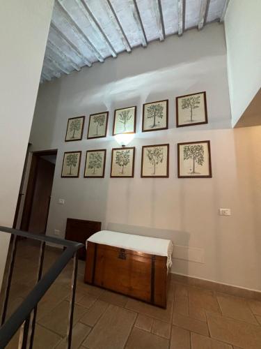 a room with a table on a wall with framed pictures at Podere Villabassa in Montespertoli