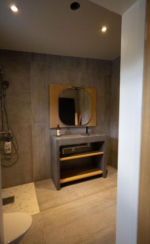 a bathroom with a tv and a mirror on the wall at New lake view cottage with Sauna in Vislanda