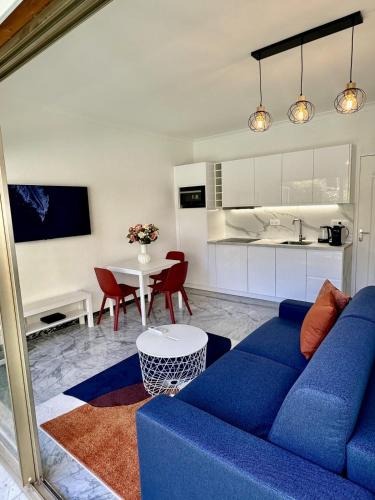 un salon avec un canapé bleu et une table dans l'établissement T2 close to the beach, à Antibes