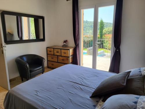 une chambre avec un lit, une chaise et une fenêtre dans l'établissement L'escapade provençale, à Lioux