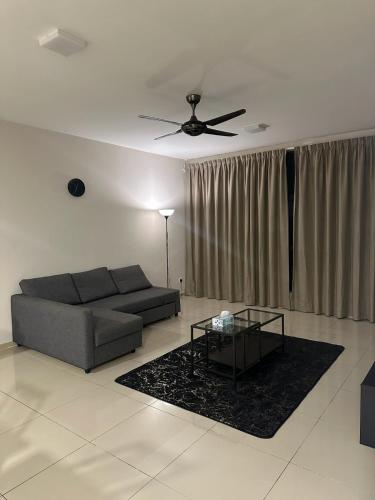 a living room with a couch and a ceiling fan at Spacious Apartment in Central Shah Alam in Shah Alam