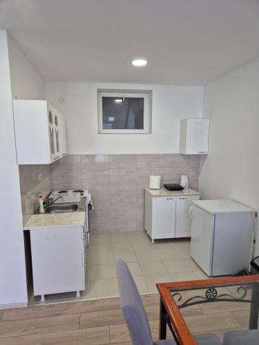 a small kitchen with white appliances and a table at Zoka in Surčin