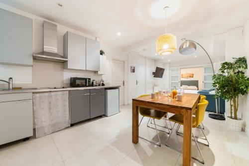 une cuisine et une salle à manger avec une table en bois dans l'établissement Loft moderne face jardin des plantes - 4P, à Paris