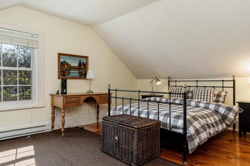 a bedroom with a bed and a table and a window at Historic 1853 Kingsgate Lakehouse in Delta
