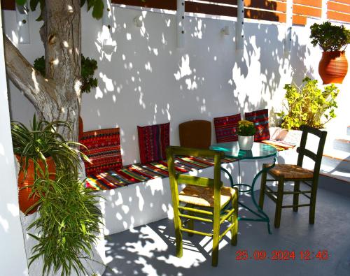 a patio with a table and chairs next to a tree at Mannas House 2 in Émbonas