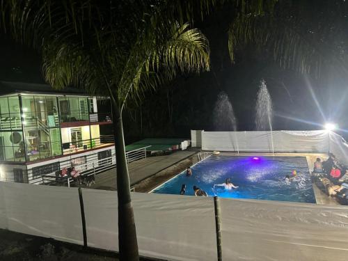 a swimming pool at night with a fountain at Finca turística el paraíso es aqui in Vergara