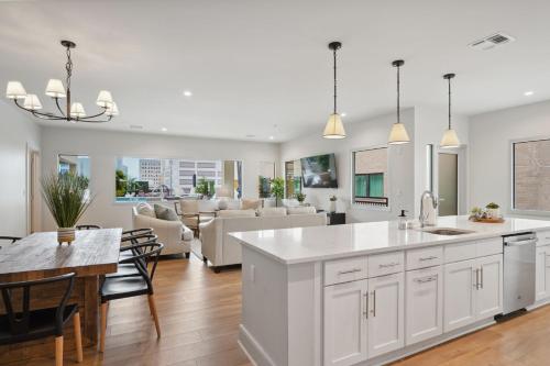 a kitchen and living room with white cabinets and a table at The Eleanor New Orleans in New Orleans