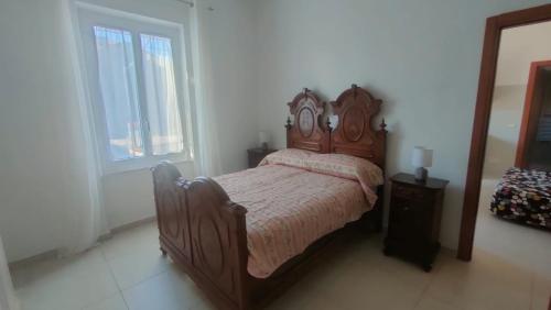 een slaapkamer met een bed met een houten hoofdeinde bij Casa Olga in La Spezia
