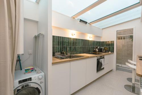 une cuisine avec une machine à laver et un évier dans l'établissement Mini Loft Buttes Chaumont, à Paris