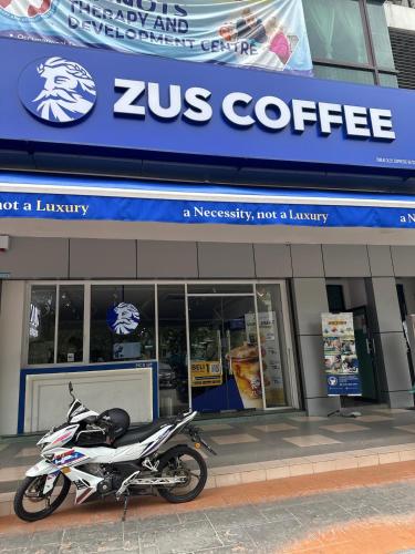 a motorcycle parked in front of a coffee shop at Spacious Apartment in Central Shah Alam in Shah Alam