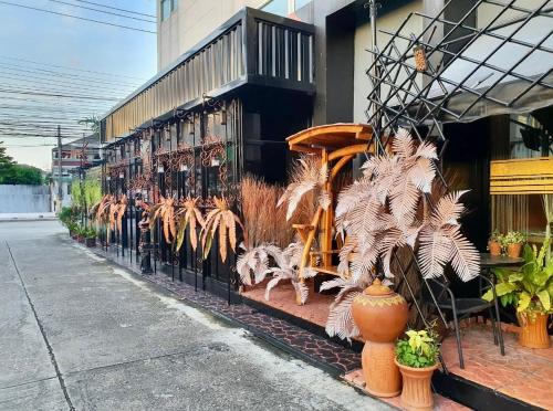 a store with a display of plants on the side of a building at โรงพักบางระมาด by ModiCoff Café in Sathani Ban Chim Phali