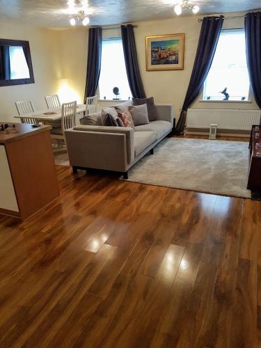 a living room with a couch and wooden floors at 1 Bedroom luxury Flat Close to town center in Northampton