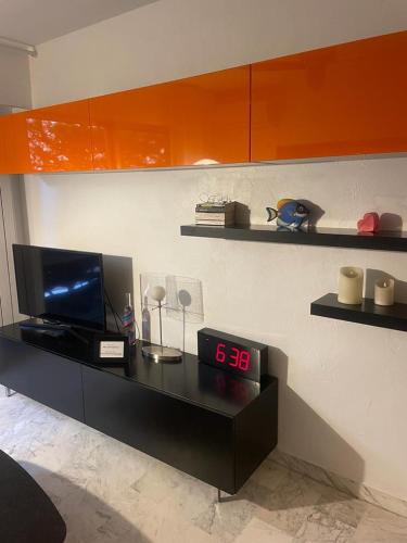 Cette chambre dispose d'une télévision et d'un réveil sur une table. dans l'établissement Apartment Cannes Croisette near seaside, à Cannes