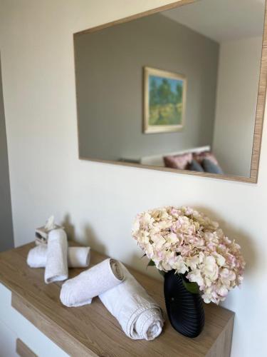 a bathroom with a mirror and a vase with flowers at Holiday Flat in Villa San Gregorio with pool in Melazzo