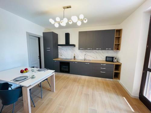 a kitchen with a white table and a counter top at Holiday Flat in Villa San Gregorio with pool in Melazzo