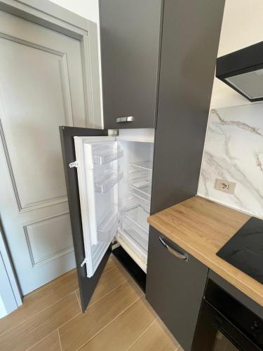an empty refrigerator with its door open in a kitchen at Holiday Flat in Villa San Gregorio with pool in Melazzo