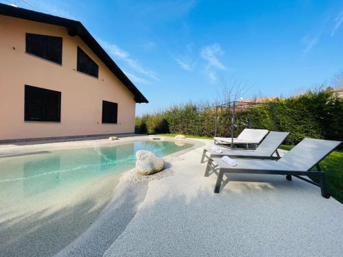 a swimming pool with two lounge chairs and a teddy bear sitting next to it at Holiday Flat in Villa San Gregorio with pool in Melazzo
