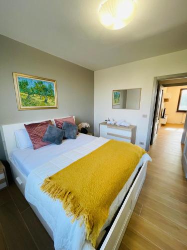 a bedroom with a large bed with a yellow blanket at Holiday Flat in Villa San Gregorio with pool in Melazzo