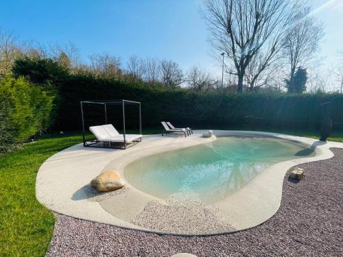 a pool with two chairs and a bench in a yard at Holiday Flat in Villa San Gregorio with pool in Melazzo