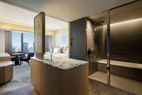 a bathroom with a shower and a vanity with a sink at THE OSAKA STATION HOTEL, Autograph Collection in Osaka