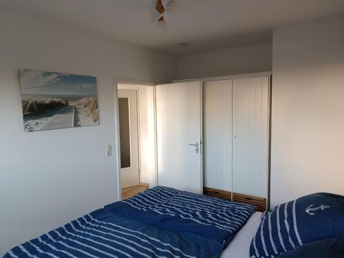 a bedroom with a blue bed and a white cabinet at Ostseemeerchen in Zingst