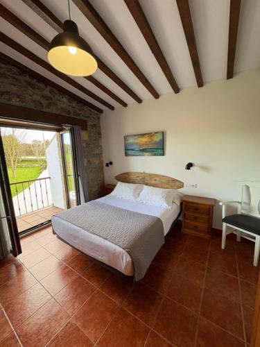 Un dormitorio con una cama y una ventana grande. en Posada Punta Liñera, en San Vicente de la Barquera