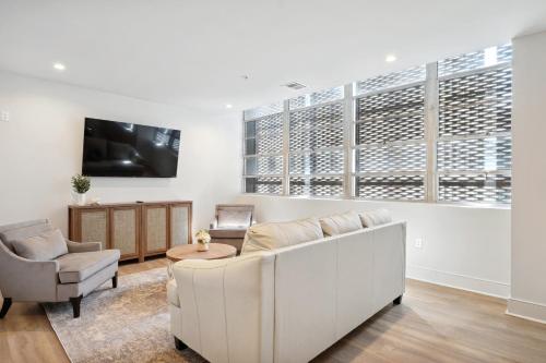 a living room with a couch and a chair and a tv at The Eleanor New Orleans in New Orleans