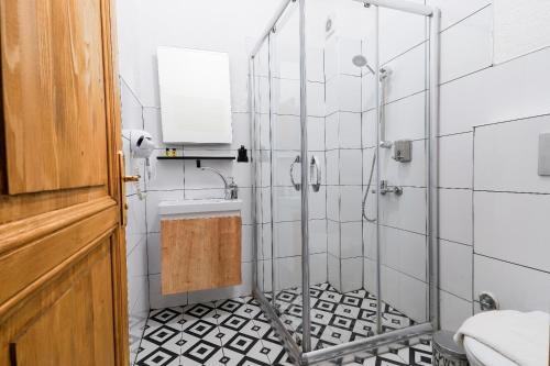 a bathroom with a shower with black and white tiles at 1826 Heritage Rooms in Taksim