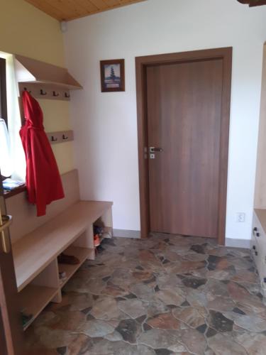 a hallway with a wooden door and a tiled floor at Duhová sova in Jílové u Držkova