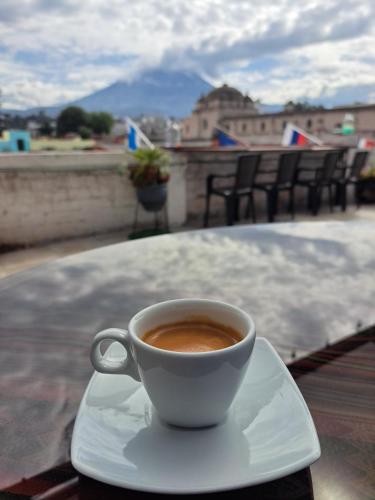 a cup of coffee sitting on a plate on a table at Holistic Scandinavia House in Arequipa