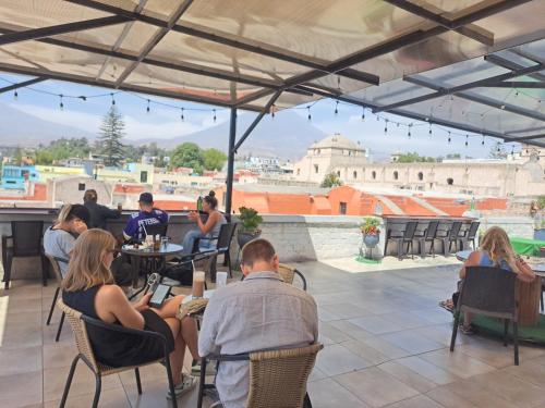 a group of people sitting at tables on a patio at Holistic Scandinavia House in Arequipa