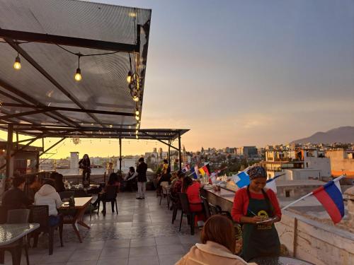 a group of people sitting on a roof with flags at Holistic Scandinavia House in Arequipa