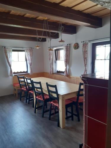 a dining room with a wooden table and chairs at Duhová sova in Jílové u Držkova