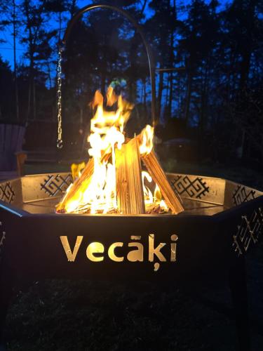 a fire pit in a yard with flames in it at House By The Sea With Hot Tub in Rīga