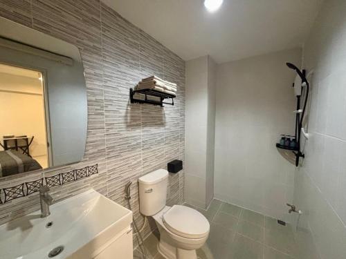 a bathroom with a toilet and a sink and a mirror at โรงพักบางระมาด by ModiCoff Café in Sathani Ban Chim Phali