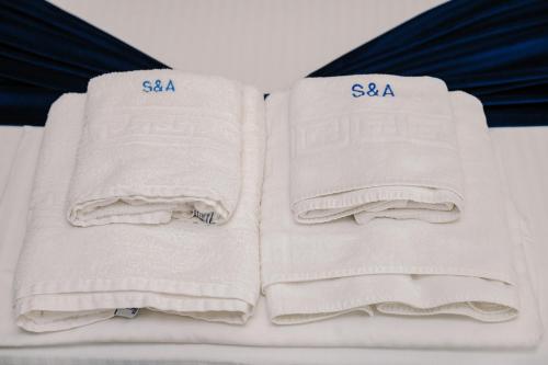two white towels sitting on top of a bed at Sim Seaside C1 in Mamaia Nord